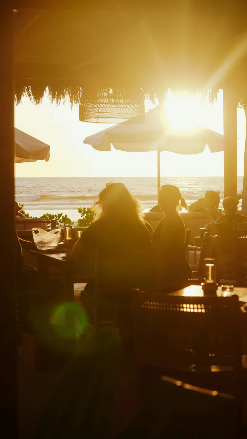 Clientes cenando en la terraza al atardecer